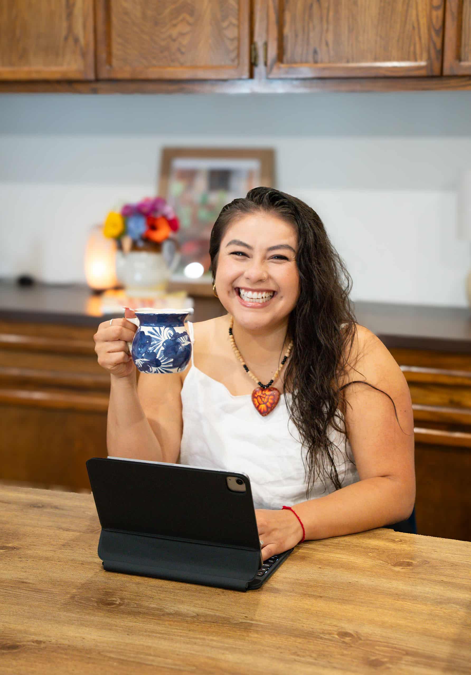 Andreina Zamudio LCSW smiling with coffee and tablet, offering consultation for clinicians and human service professionals in Long Beach, CA