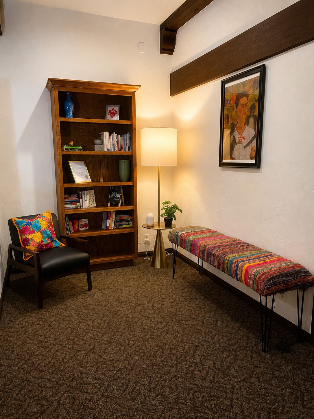 Waiting area in Andreina Zamudio LCSW's Long Beach therapy office, with bookshelf, seating, and Frida Kahlo inspired art