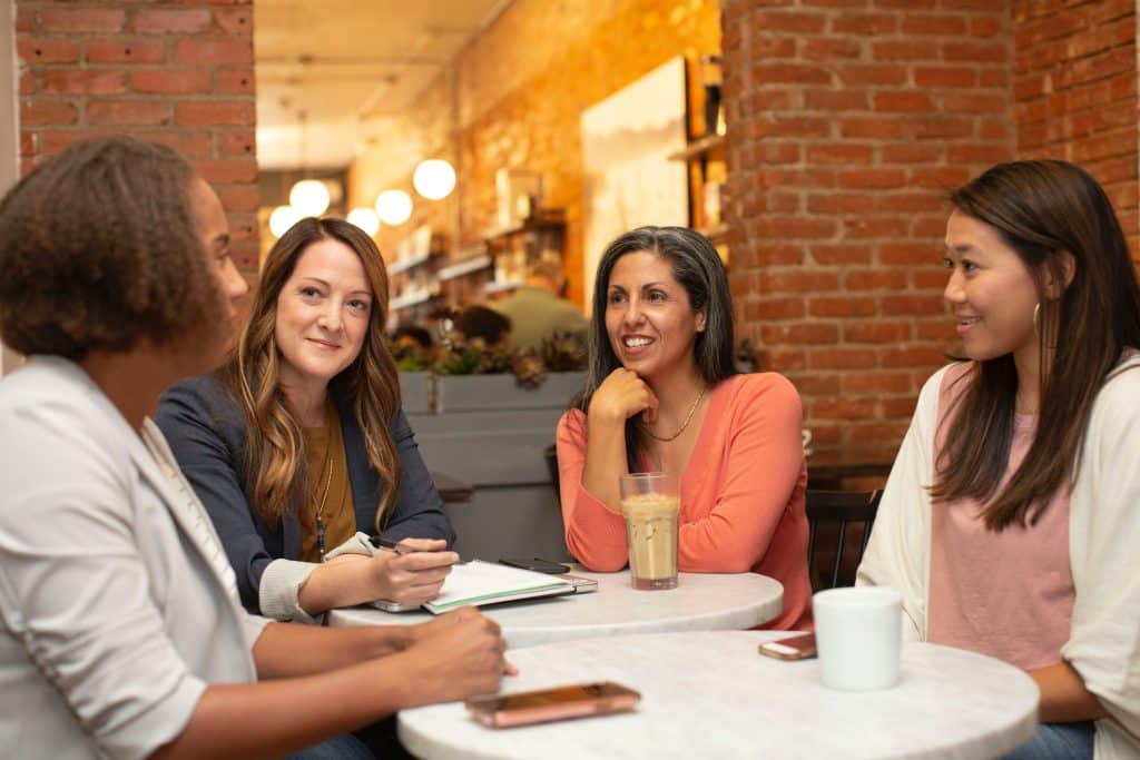 Group of women having a conversation over coffee at a cafe table